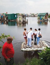 عمال الرعاية الصحية يركبون طوفًا مؤقتًا إلى المنازل لتطعيم المواطنين طريحي الفراش ضد مرض فيروس كورونا في مدينة فالينزويلا، الفلبين.      (رويترز)