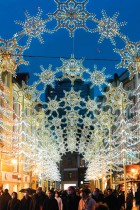 متسوقون يمشون أمام أضواء عيد الميلاد وهي تضيء شارعًا في مولهاوس بشرق فرنسا. ا ف ب