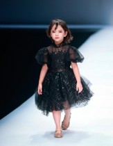 عارضة تقدم أزياء للأطفال من ابتكار مجموعة KUNJIE خلال أسبوع الموضة الصيني في بكين. ا ف ب