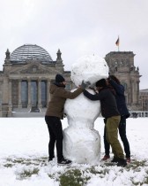 أشخاص يصنعون رجل ثلج أمام مبنى الرايخستاغ في العاصمة الألمانية برلين.   (رويترز)