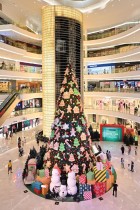 متسوقون يمشون أمام زينة عيد الميلاد في مركز تسوق في جاكرتا.  (ا ف ب)
