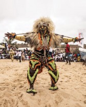 رجل يرتدي زيًا تقليديًا ويؤدي عروضه للمشجعين خلال سباق الدراج السنغالي التقليدي في داكار. ا ف ب