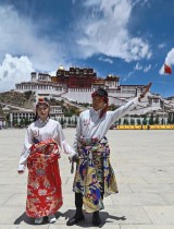شاب وفتاة يرتديان الزي التقليدي ويقفون أمام قصر بوتالا - الذي صنفته اليونسكو كموقع للتراث العالمي في عام 1994 - في لاسا بمنطقة التبت الصينية ذاتية الحكم. ا ف ب
