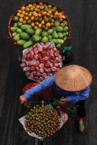 بائعة تحمل فواكه للبيع على دراجتها على طول شارع في هانوي فيتنام - ا ف ب