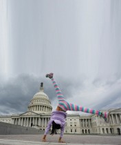 الطفلة فاليريا رويز (10 سنوات) من كولومبيا، تقوم بحركة بهلوانية أثناء زيارتها لمبنى الكابيتول الأمريكي. (رويترز)