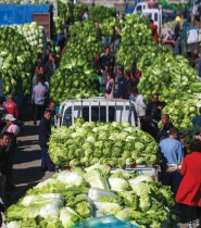 بائعو الخضروات ينتظرون العملاء في سوق في شنيانغ بمقاطعة لياونينغ شمال شرق الصين. (ا ف ب) 