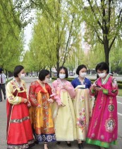 نساء يرتدين فساتين الهانبوك التقليدية يسرن في بيونغ يانغ حيث تحتفل البلاد بالذكرى التسعين لتأسيس الجيش. ا ف ب