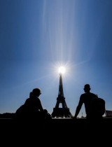 السياح يستمتعون بالنظر إلى برج إيفل في ميدان تروكاديرو في يوم دافئ ومشمس في باريس. رويترز