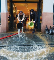 موظفو متجر ملابس يفرغون دلاء ماء أثناء تنظيفهم لمتجرهم الذي غمرته المياه بعد ارتفاع الفيضانات بالقرب من فرانكفورت بألمانيا. رويترز