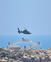السائحون ينظرون إلى طائرة هليكوبتر عسكرية صينية تحلق فوق جزيرة بينغتان، وهي أقرب نقطة في البر الرئيسي للصين من تايوان، ضمن مناورات ضخمة قبالة تايوان بعد زيارة نانسي بيلوسي إلى الجزيرة. ا ف ب