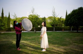 بينغ جينغ، 24 عامًا ، في جلسة تصوير قبل حفل زفافها بعد رفع الإغلاق في ووهان الصينية والتي كانت مركز بؤرة تفشي فيروس كورونا. (رويترز)