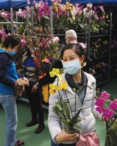 عملاء يرتدون أقنعة الوجه يشترون الزهور خلال معرض السنة القمرية الجديدة في فيكتوريا بارك ، في هونغ كونغ ، الصين.   رويترز
