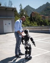 دانييل بوتشي ، الباحث الرئيسي في الذكاء الاصطناعي يرافق الروبوت icub 3أثناء سيره على سطح موقف السيارات في المعهد الإيطالي للتكنولوجيا (IIT) في جنوة. ا ف  ب