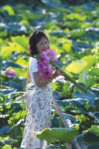 امرأة تستمتع بالزهور والطبيعة الساحرة في ويستليك لوتس بالعاصمة الفيتنامية هانوي. ا ف ب