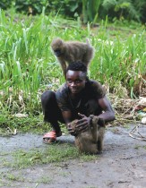 صبي يلعب مع قردين في فناء مسكن خاص بمنطقة مواندا في فرانسفيل في قلب غابات الجابون 2020. ا ف ب