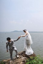 زوجان أثناء جلسة تصوير لزفافهما، بجوار البحيرة الشرقية في ووهان، بمقاطعة هوبي وسط الصين. ا ف ب