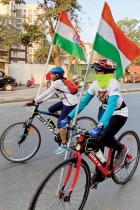 أشخاص يركبون دراجاتهم على الطريق حاملين الأعلام الوطنية خلال احتفالات يوم الجمهورية في مومباي. ا ف ب