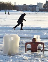 سباح شتوي يغطس في المياه المتجمدة وسط الجليد البحري في هلسنكي، فنلندا. رويترز