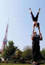 رجل وزوجته يرتديان أقنعة واقية للوجه أثناء أدائهما رياضة «أكرو يوغا» في حديقة بجوار برج طوكيو، وسط تفشي فيروس كورونا في اليابان.رويترز