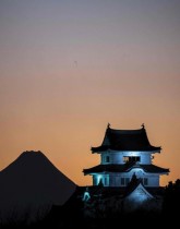 قلعة سيكيادو مضاءة ليلاً بينما يلوح في الأفق جبل فوجي، أعلى جبل في اليابان. ا ف ب
