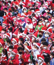 طلاب يرتدون أزياء بابا نويل ، قبل زيارة خمسة أفيال ترتدي أزياء سانتا كلوز، ضمن احتفالات عيد الميلاد في مدرسة ابتدائية في تايلاند.    (رويترز)