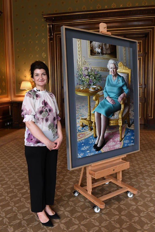 الفنانة ميريام إسكوفيت تقف بجوار صورة رسمتها للملكة إليزابيث ملكة بريطانيا في وزارة الخارجية والكومنولث في لندن. رويترز