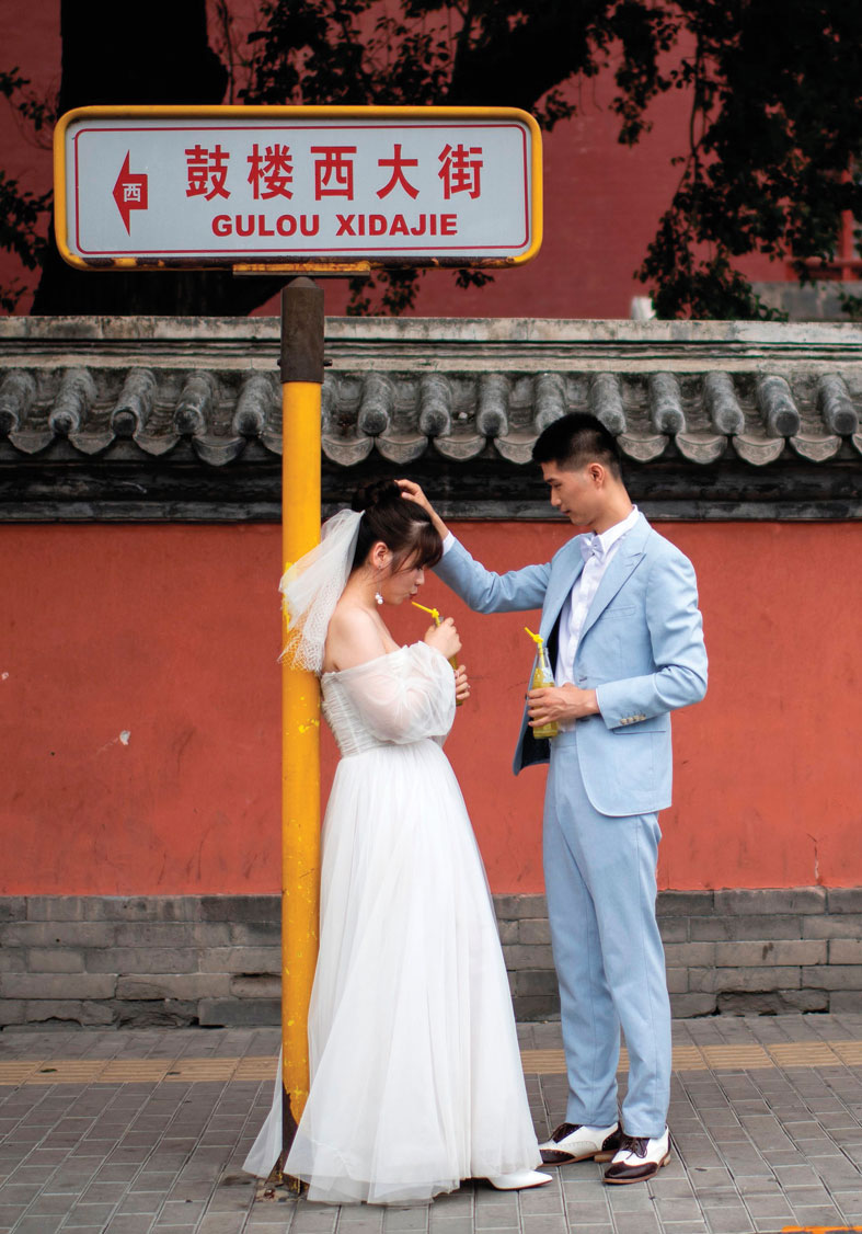 زوجان يقفان خلال جلسة تصوير قبل الزفاف في بكين.   ا ف ب