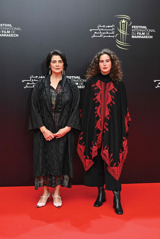 الممثلة والمخرجة الفلسطينية هيام عباس والمخرجة الفرنسية الجزائرية لينا سوالم على السجادة الحمراء خلال الدورة العشرين لمهرجان مراكش السينمائي الدولي. (ا ف ب)