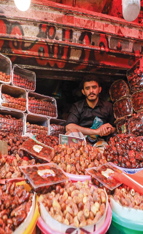 بائع تمر يجلس في كشكه في سوق باليمن خلال شهر رمضان المبارك. (ا ف ب)