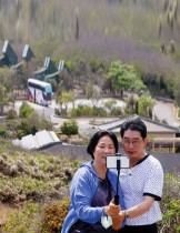 سائح وزوجته يلتقطان صورة سيلفي مع قاذفات صواريخ متنقلة من طراز Hsiung Feng في الخلفية في حديقة كاب ماوبيتو، تايوان. رويترز