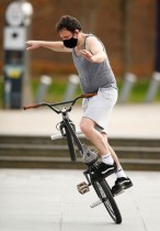 شخص يرتدي قناع وجه واقٍ ويمارس هوايته باللعب على دراجة في بلفاست، مع استمرار انتشار فيروس كورونا في أيرلندا الشمالية.رويترز