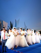 حفل زفاف جماعي في جزيرة هاينان جنوب الصين للأزواج الذين أجلوا حفلات الزفاف للعمل على الخطوط الأمامية لمحاربة فيروس كورونا.    (ا ف ب)