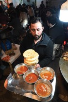 عامل باكستاني يقدم الطعام لوجبة السحور قبل بداية صيام رمضان في شارع كارتاربورا للطعام في روالبندي. (ا ف ب)