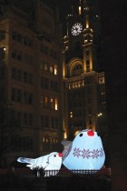 العمل الفني الطيور المغردة تضيء بجوار مبنى ليفر في ليفربول ، شمال غرب إنجلترا قبل مسابقة Eurovision للأغاني. (ا ف ب) 