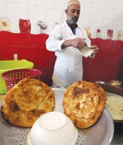 عامل ليبي يقوم بإعداد البيض والخبز المقلي (السفينز) ليقدم للزبائن خلال شهر رمضان في طرابلس. (ا ف ب)