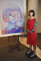 Ai-Da أول فنانة روبوت تتمتع بذكاء اصطناعي فائق الواقعية في العالم ويمكنها الرسم والتلوين، تم تصويره جنبًا إلى جنب مع صورتها الذاتية في متحف التصميم في لندن.  (ا ف ب)