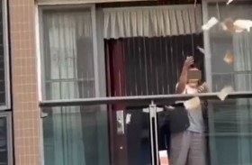 صينية تنثر ثروتها من شرفة المنزل وتشل حركة المرور