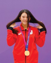اليابانية هينانو كوساكي الحائزة على الميدالية الذهبية على منصة التتويج بعد فوزها بنهائي حديقة السيدات في الصين  - رويترز