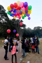 العائلات تشتري البالونات من بائع لأطفالها في إحدى حدائق دكا. بنغلاديش ا ف ب