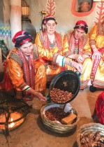 نساء يرتدين ملابس تقليدية يتجمعن أثناء تحميص الفول السوداني خلال احتفال بمناسبة اليوم العالمي للمرأة ، في قرية الساحل ، في منطقة القبائل في الجبال شرق الجزائر العاصمة.  رويترز